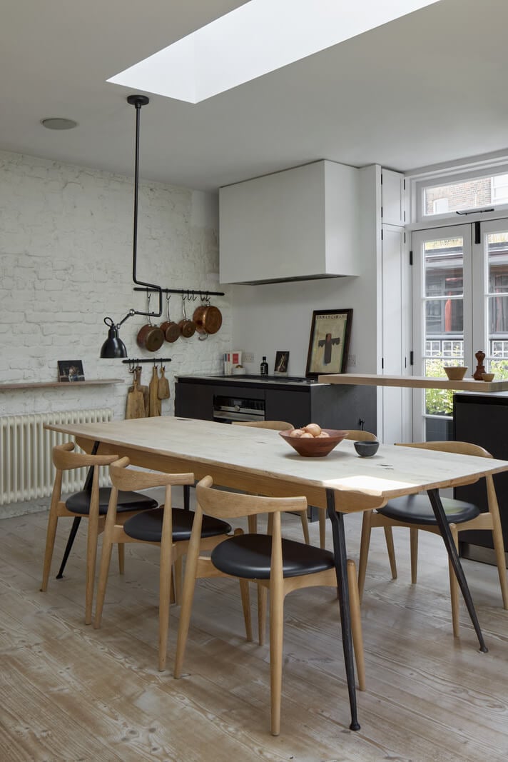 A Black and White Primrose Hill Mews House with a Roof Terrace 3 modern kitchen dining table brick wall