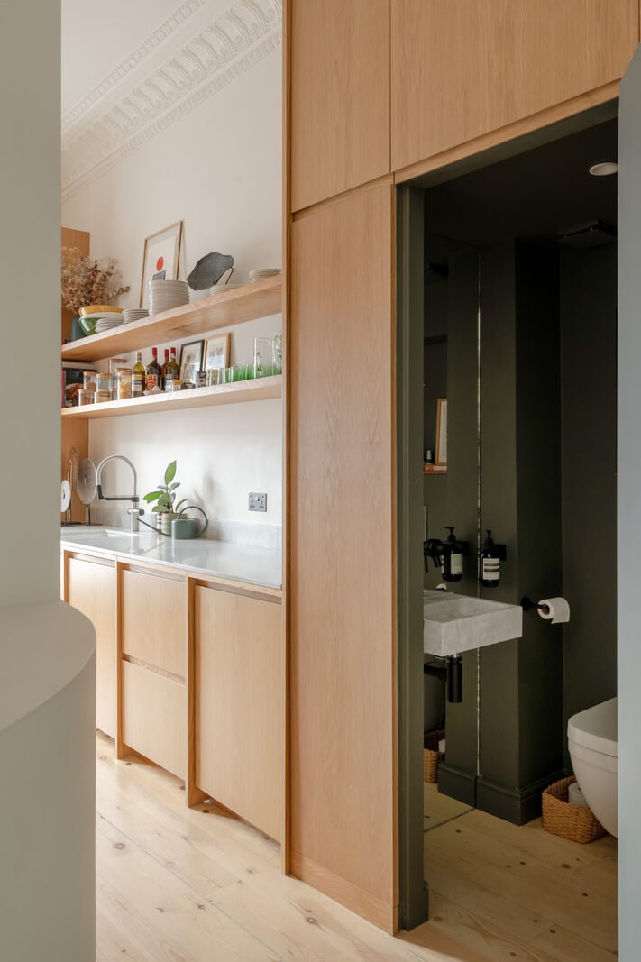 Historic Charm and Modern Design in a Light-Filled Pimlico Apartment 10 oak kitchen and door leading to green guest toilet