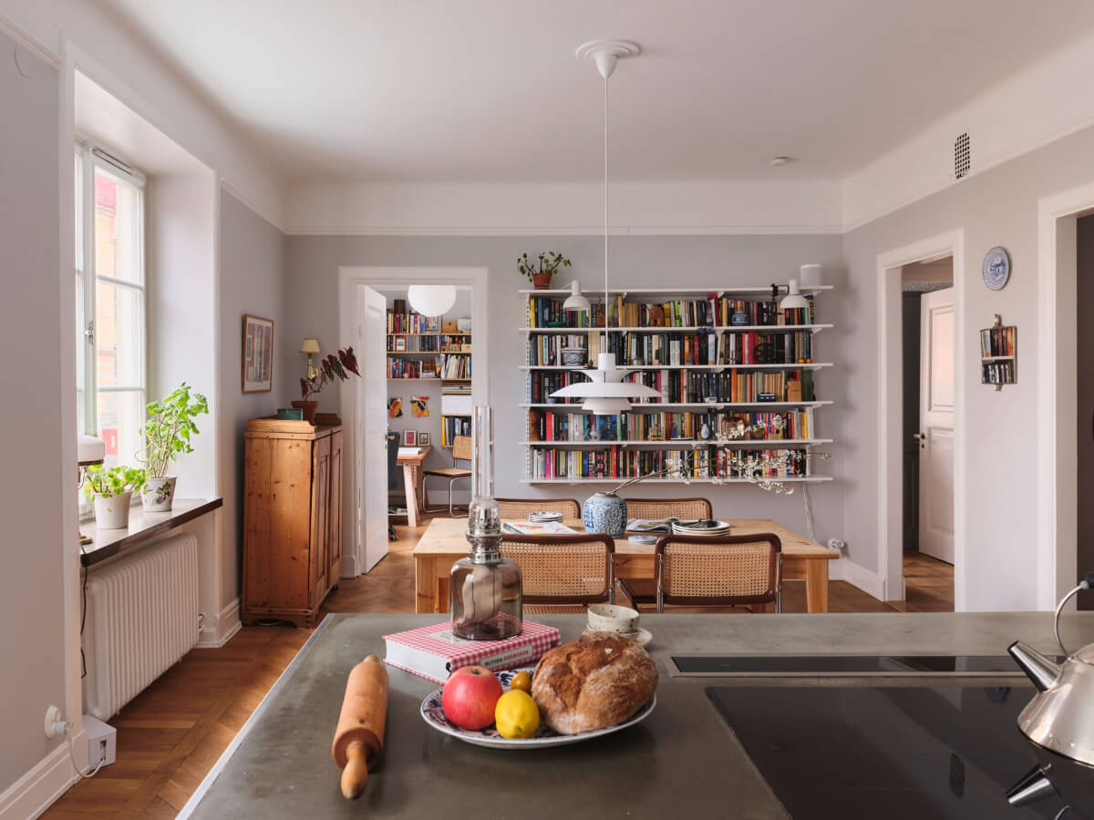 An Early 20th Century Apartment with a Muted Green Kitchen 6 open plan kitchen dining space bookshelves