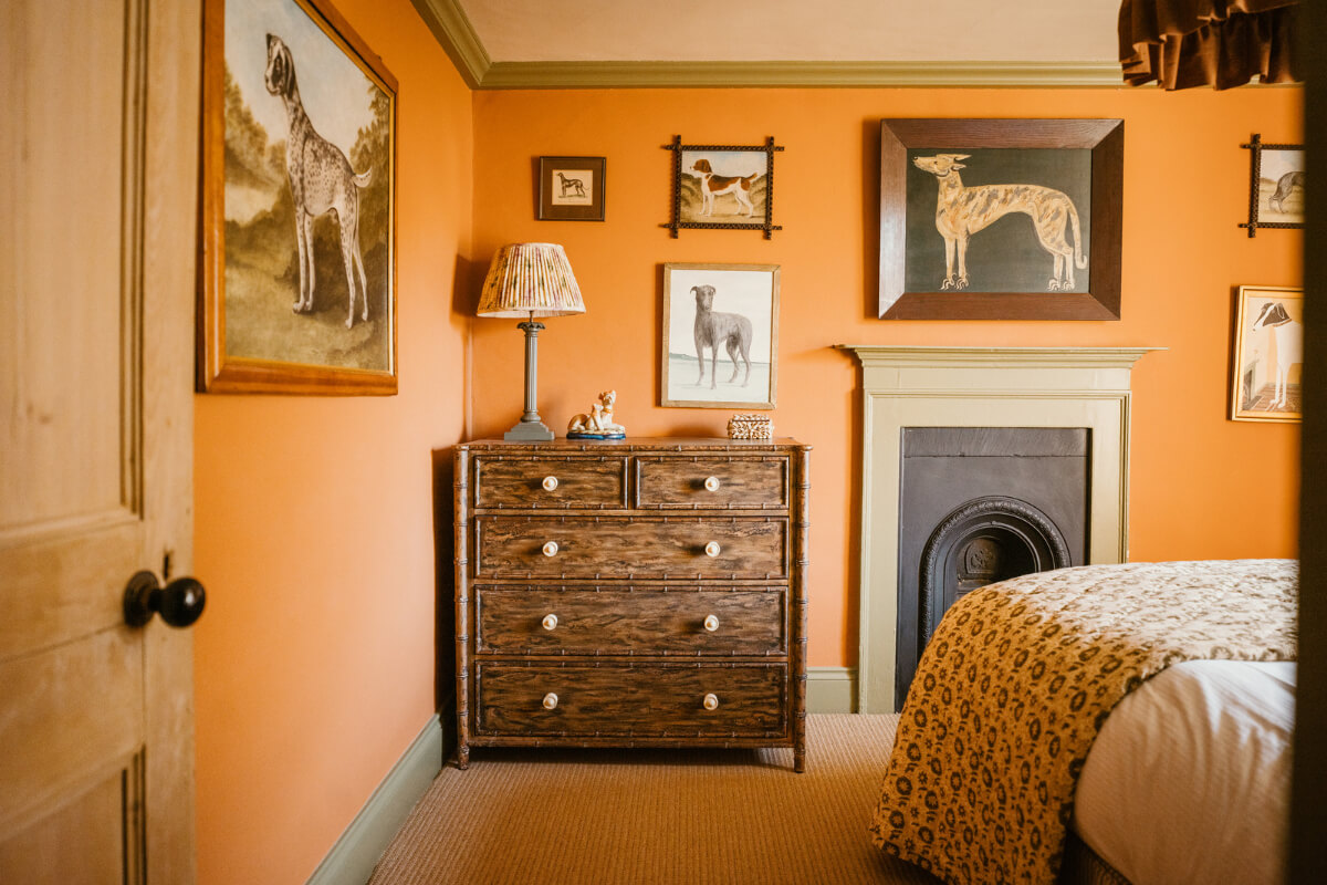 Bespoke Interiors and an Earthy Color Palette in a Historic Cottage 15 orange bedroom sisal carpeting fireplace