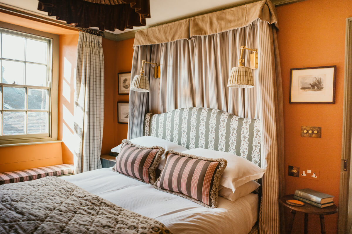 Bespoke Interiors and an Earthy Color Palette in a Historic Cottage 16 orange bedroom window seat striped canopy