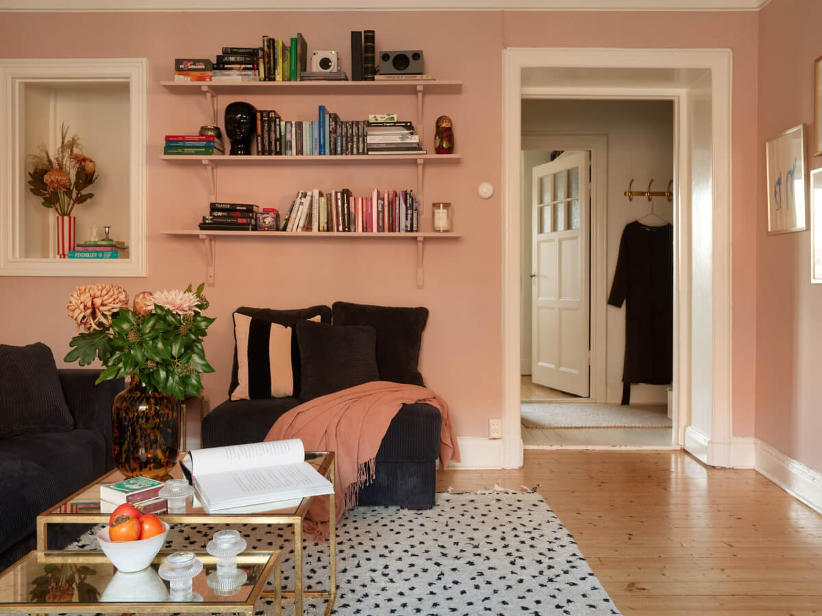 Historic Charm and an Industrial Glass Wall in a Stockholm Apartment 13 pink living room shelves green sofa