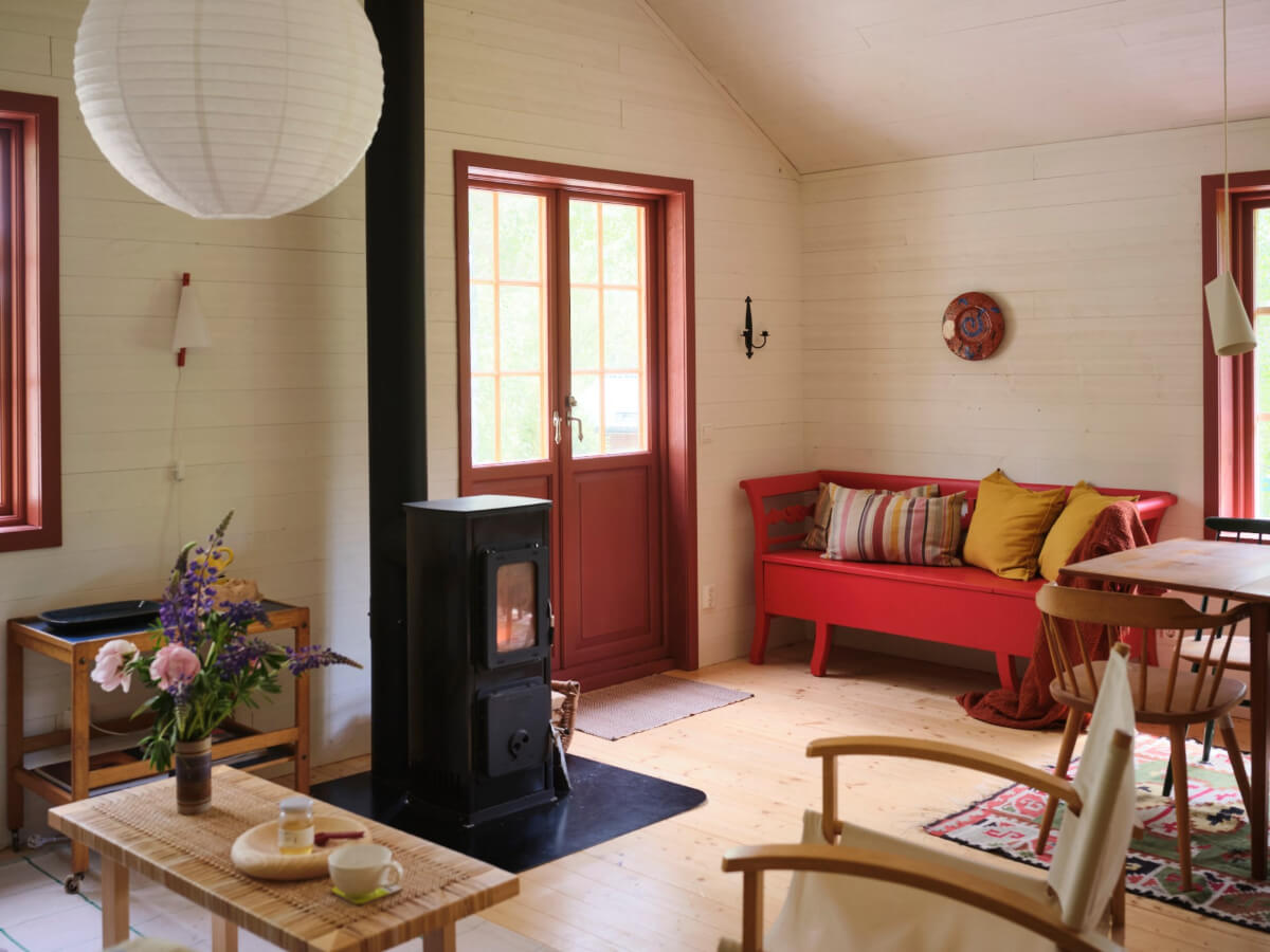 A Charming, Extended 19th-Century Log House in Sweden 5 red bench and log burner