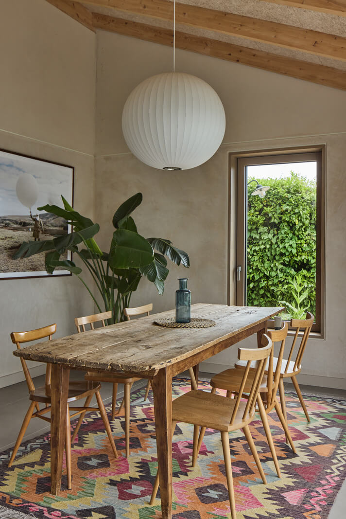 A Modern Bungalow with a Terrazzo Kitchen and Magnificent Views 4 rustic wooden dining table colorful rug