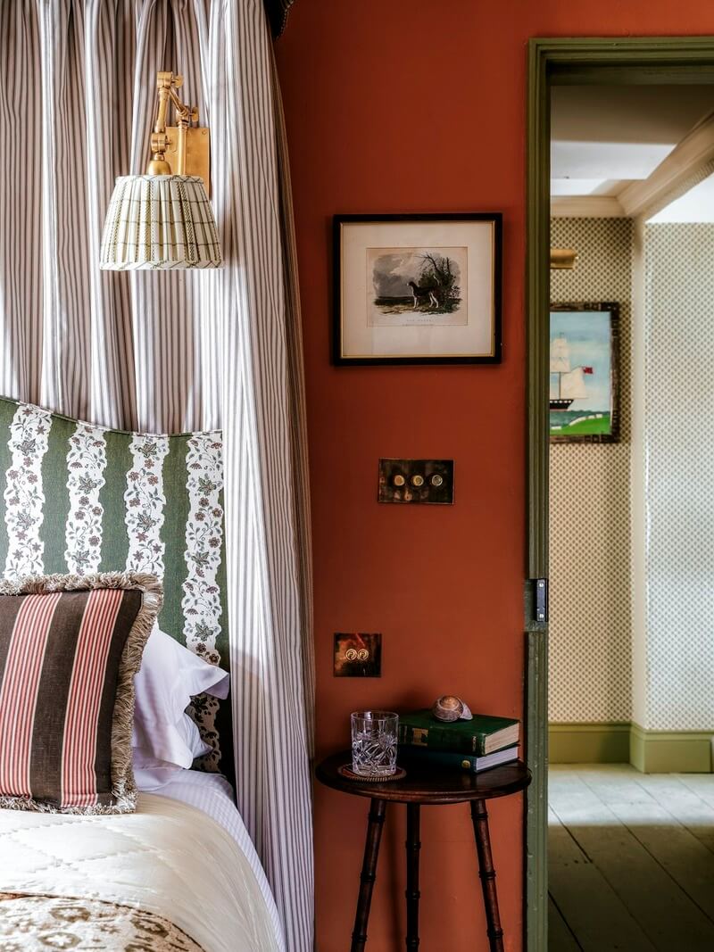 Bespoke Interiors and an Earthy Color Palette in a Historic Cottage 18 striped canopy upholstered headboard orange bedroo