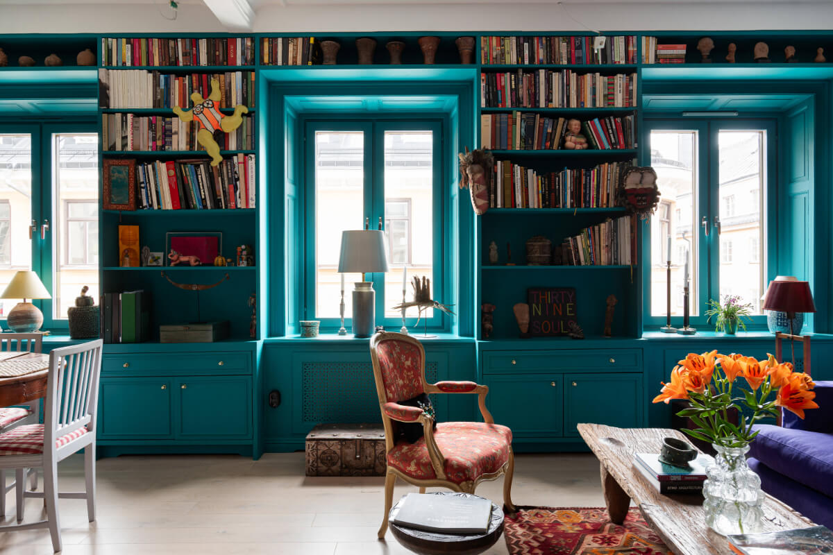 Bold Teal Walls and Antiques in a Turn-of-the-Century Apartment 4 teal green living room built-in bookshelves around windows
