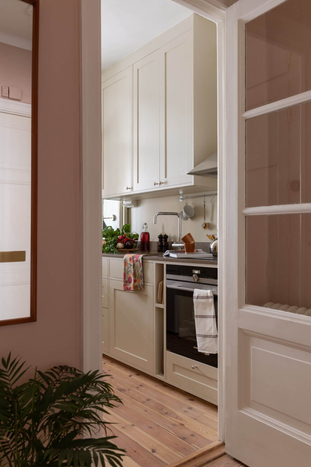 A Nice Color Palette and Original Elements in a Cozy 1930s Apartment 13 view into kitchen glass timber door