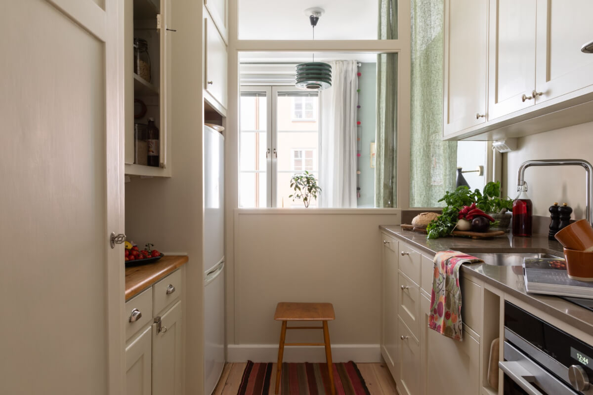 A Nice Color Palette and Original Elements in a Cozy 1930s Apartment 14 white galley kitchen