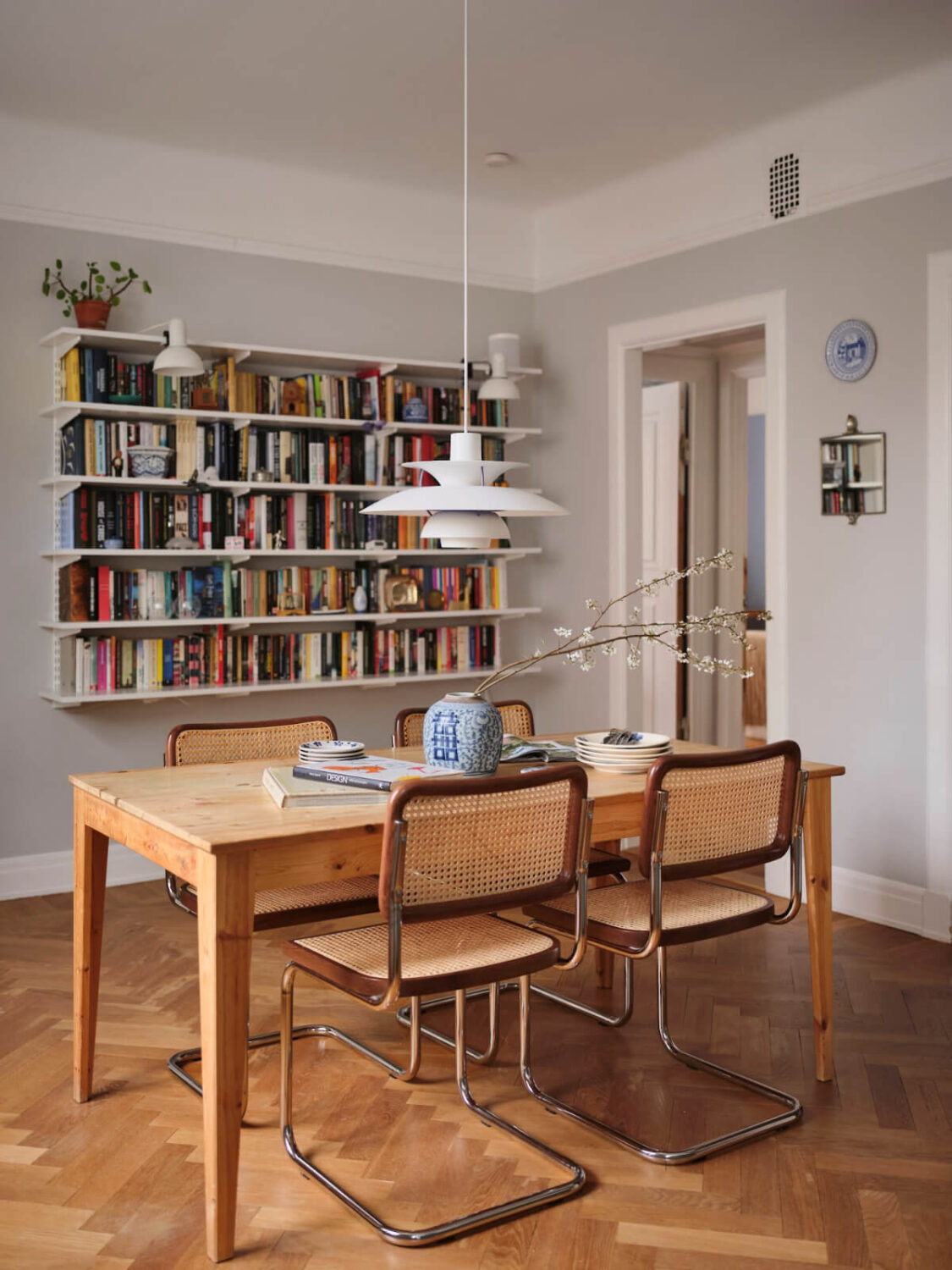 An Early 20th Century Apartment with a Muted Green Kitchen 7 wooden dining table bookshelves