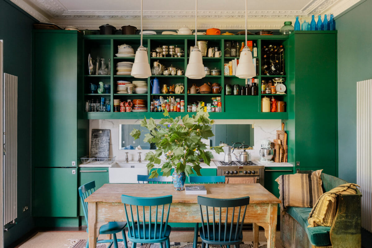 A Rich Color and Material Palette in a Small Victorian Apartment 3 green kitchen open upper cabinets rustic dining table