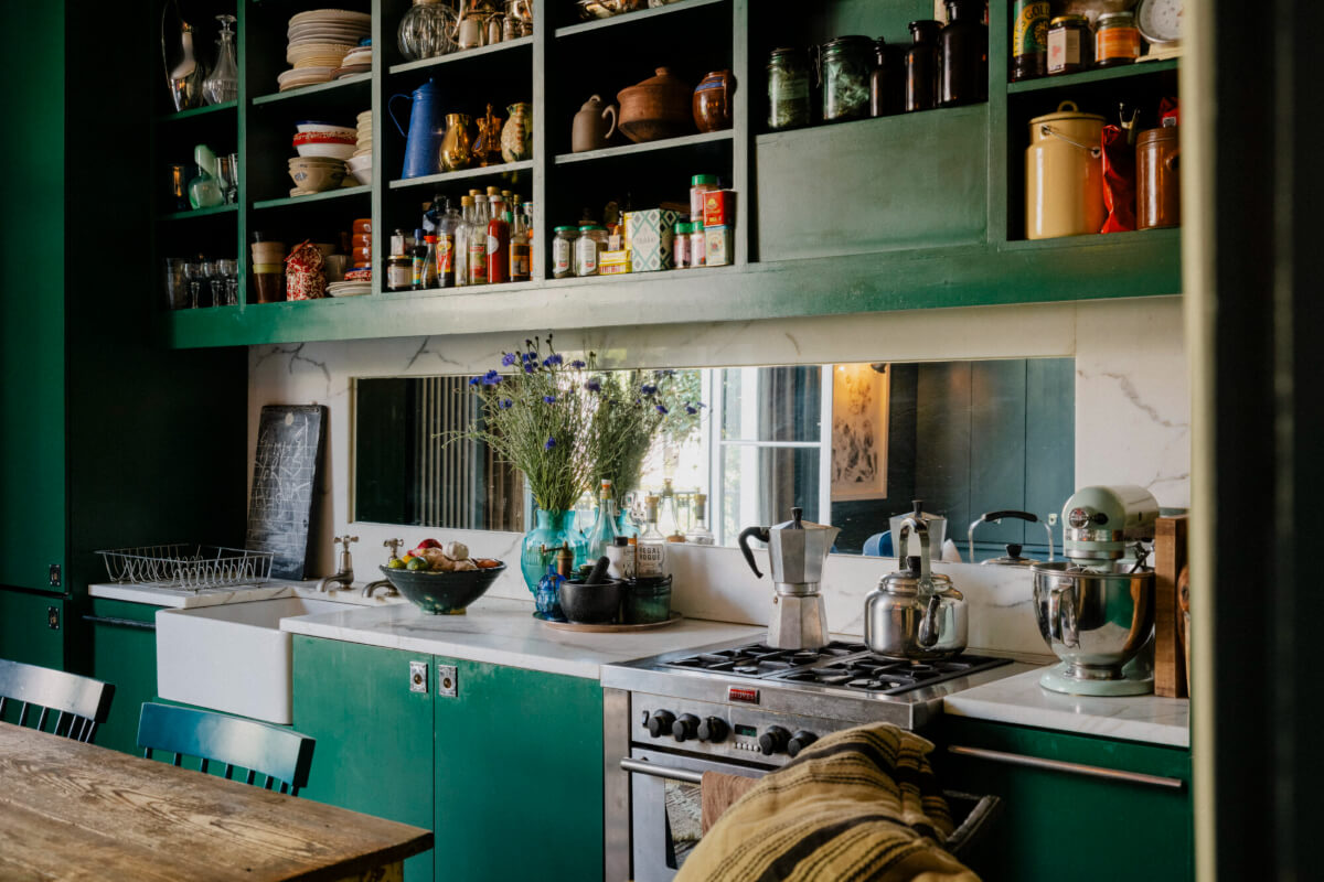 A Rich Color and Material Palette in a Small Victorian Apartment 4 green kitchen with marble and mirror backsplash