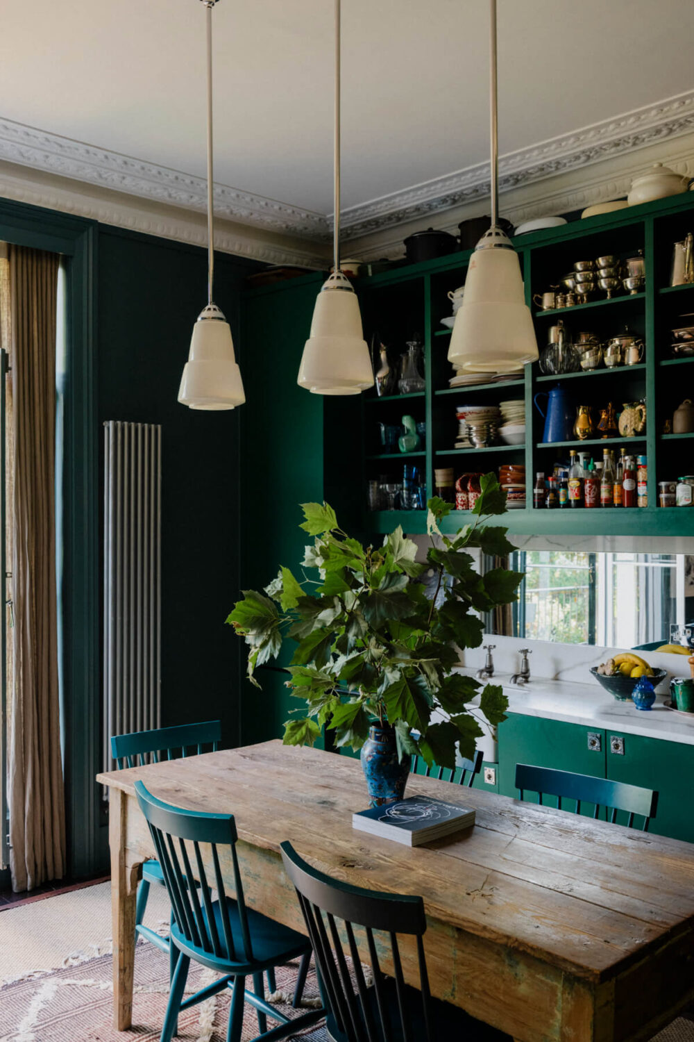 Why Everyone’s Adding Mirrors to Their Kitchens (And You Should Too) 7 green kitchen with rustic dining table open cabinets and mirror backsplash