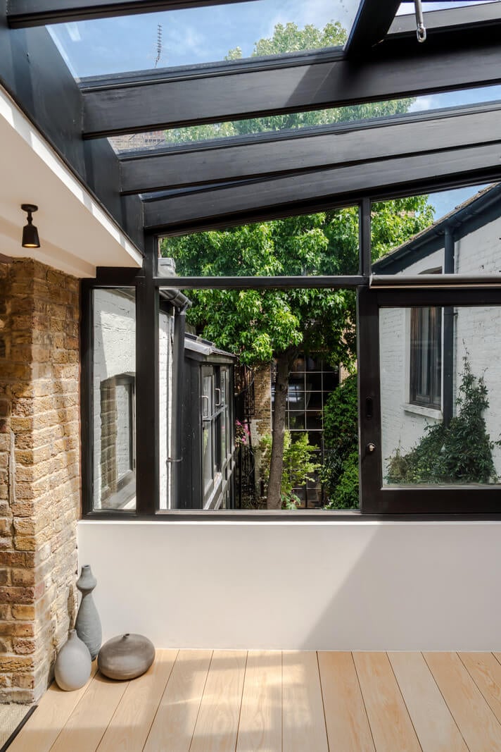 An Industrial Mews House with a Sebastian Cox deVOL Kitchen 17 large windows overlooking courtyard terrace