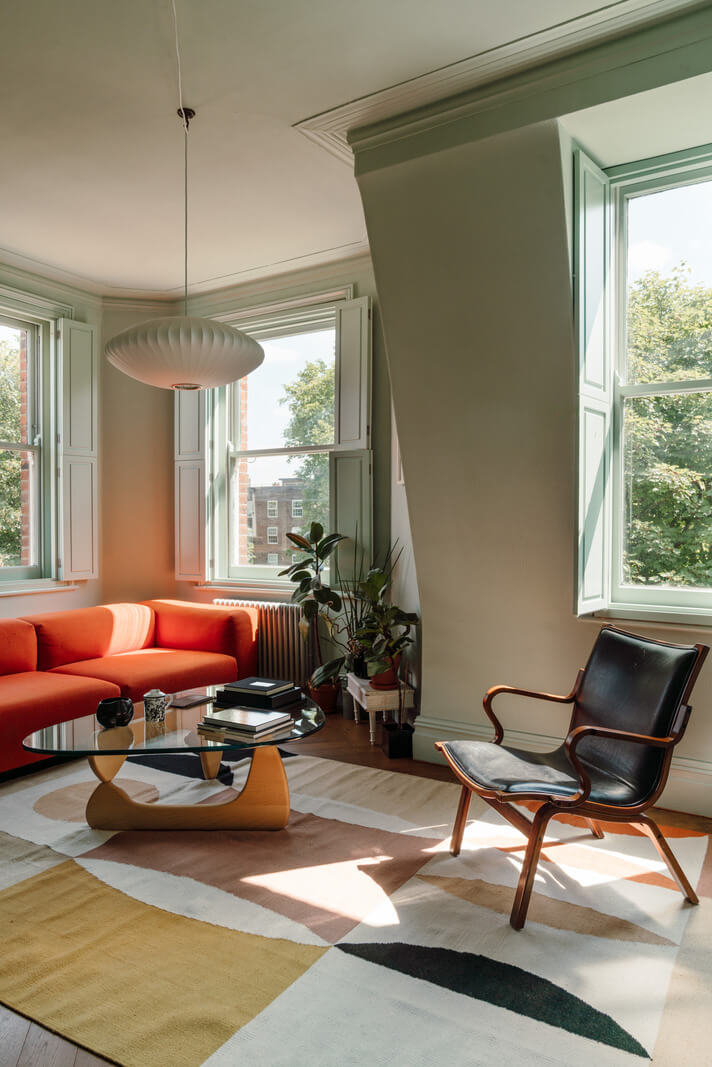 Pastel Tones and Deep Yellow in an Early 20th-Century London Apartment 2 living room orange sofa large rug