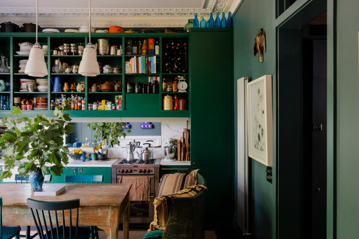 A Rich Color and Material Palette in a Small Victorian Apartment 5 open upper cabinets green kitchen with rustic table