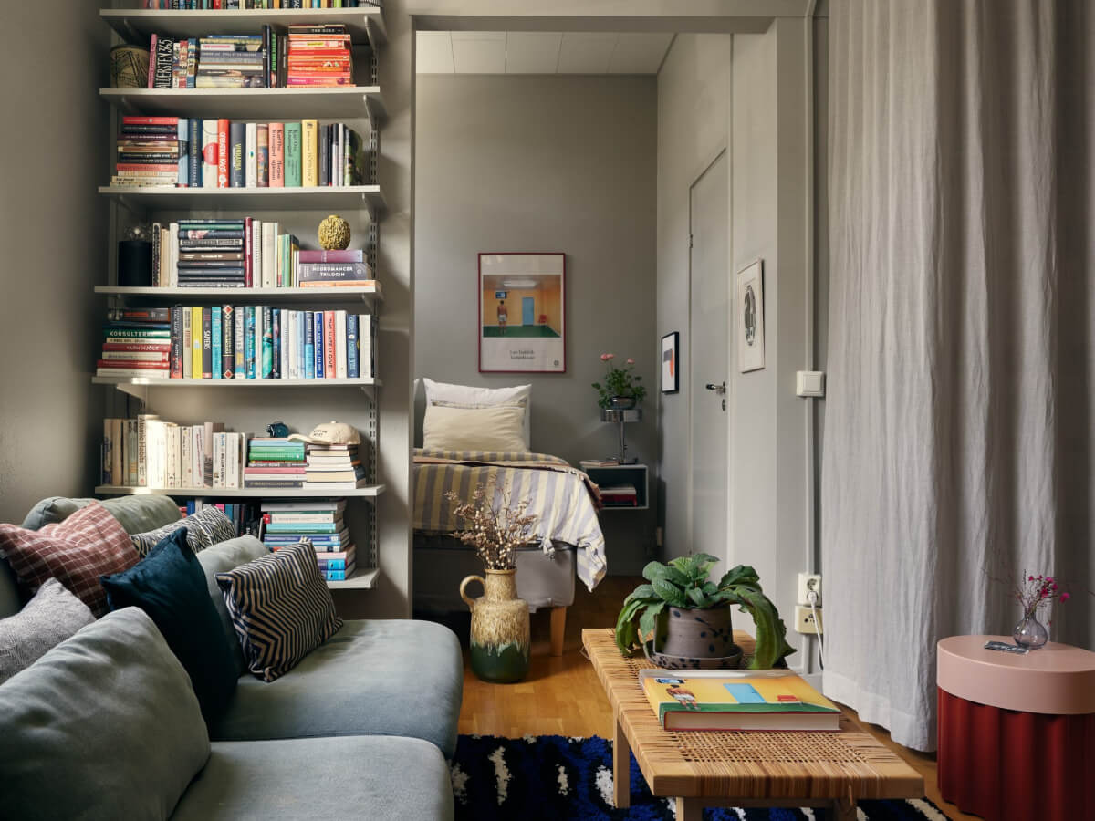 A Tiny Apartment with a Semi-Open Floorplan and a Pink Kitchen 2 semi-open gray apartment with bookshelves