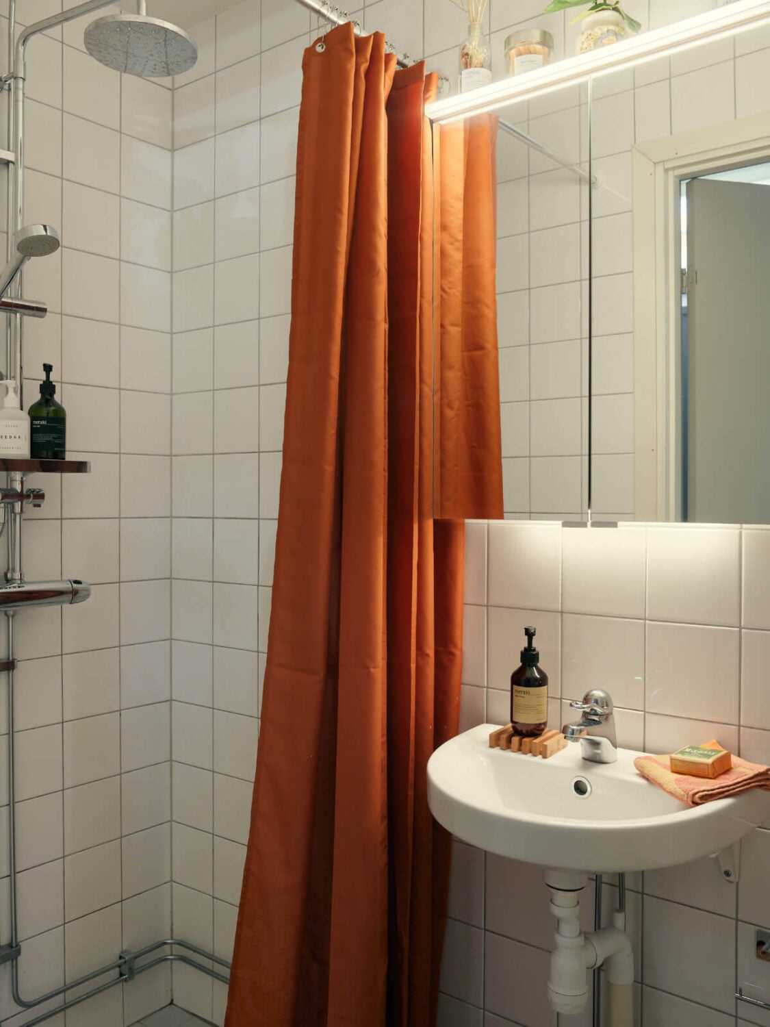 A Tiny Apartment with a Semi-Open Floorplan and a Pink Kitchen 16 small bathroom terracotta shower curtain