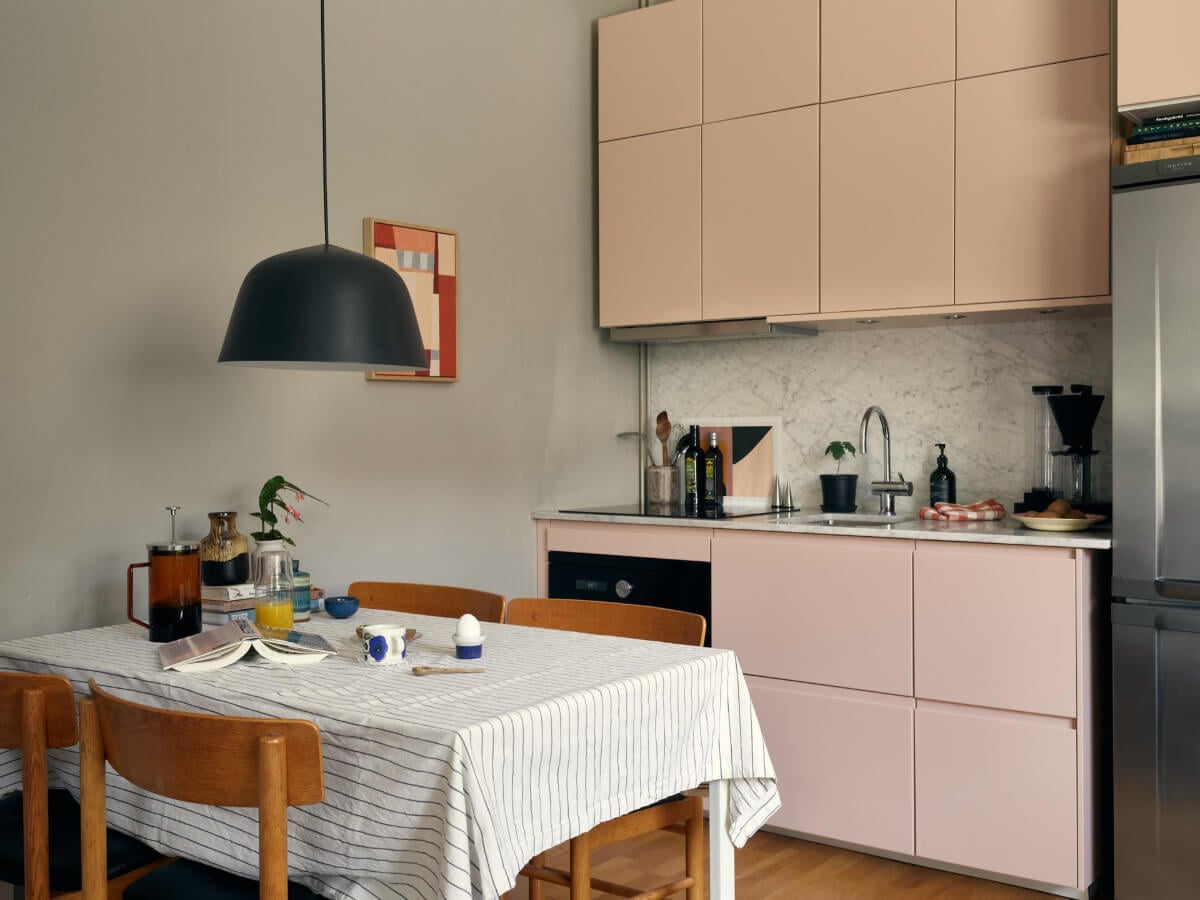 A Tiny Apartment with a Semi-Open Floorplan and a Pink Kitchen 7 small light pink kitchen double row upper cabinets