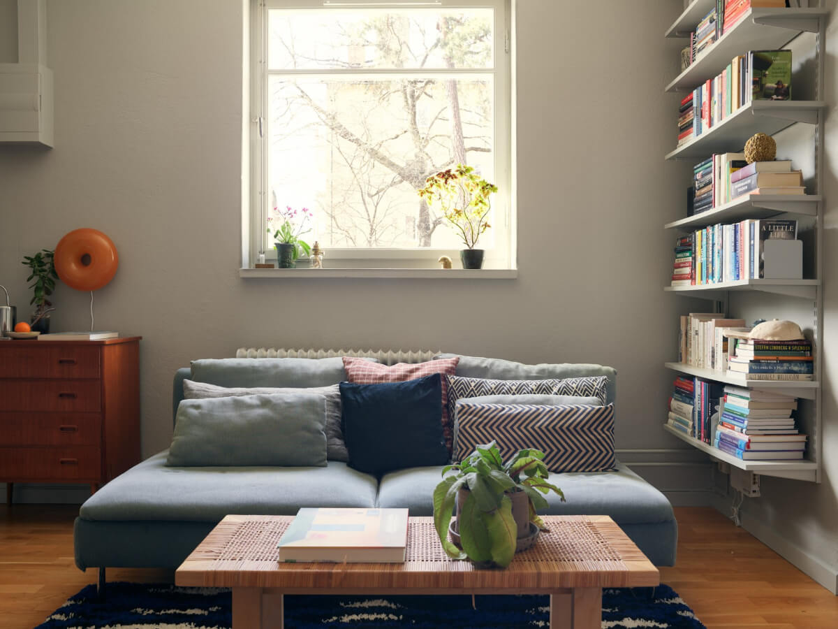 A Tiny Apartment with a Semi-Open Floorplan and a Pink Kitchen 3 small sitting area rattan coffee table bookshelves