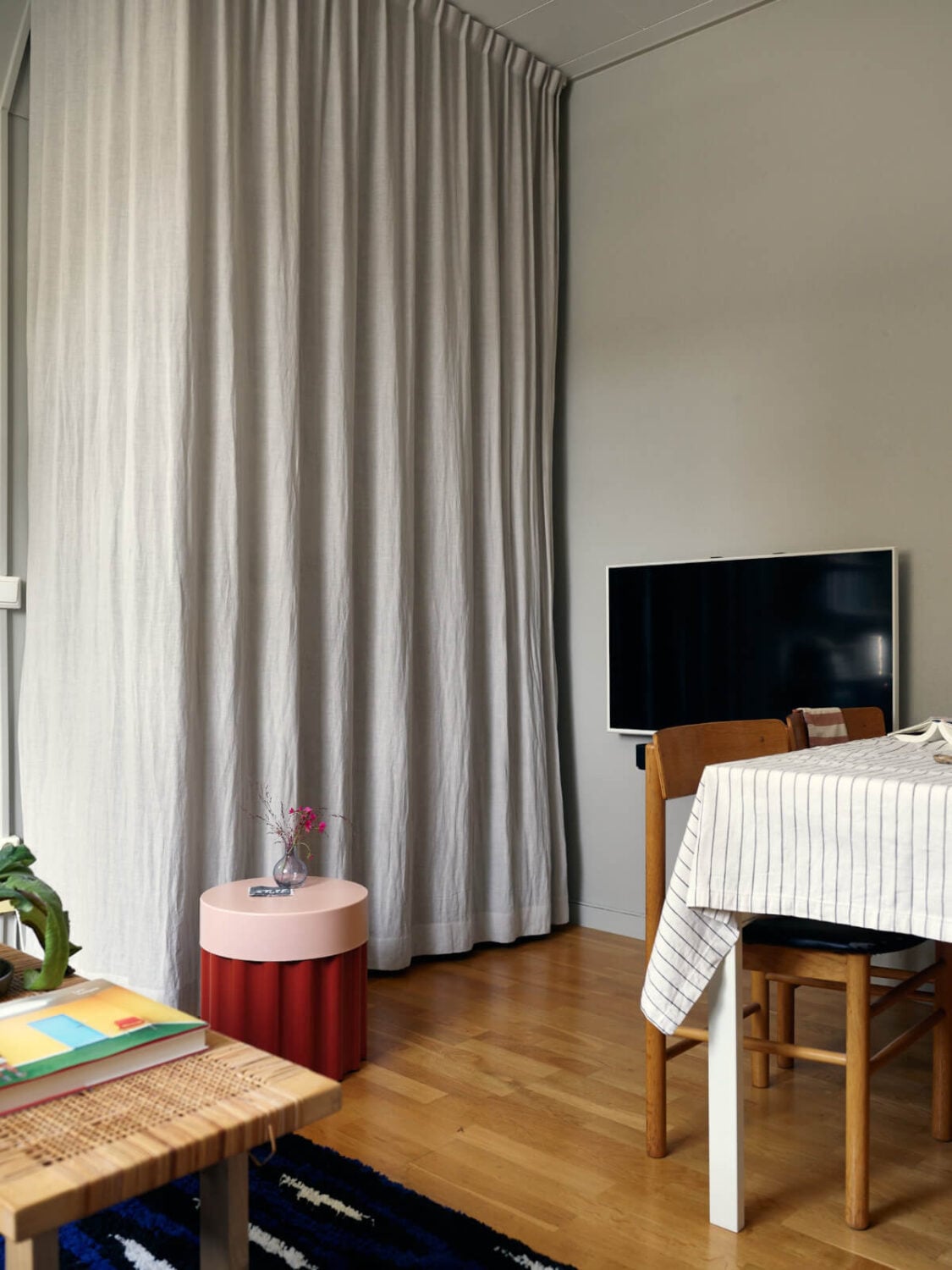A Tiny Apartment with a Semi-Open Floorplan and a Pink Kitchen 12 storage behind linen curtains A Tiny Apartment with a Semi-Open Floorplan and a Pink Kitchen