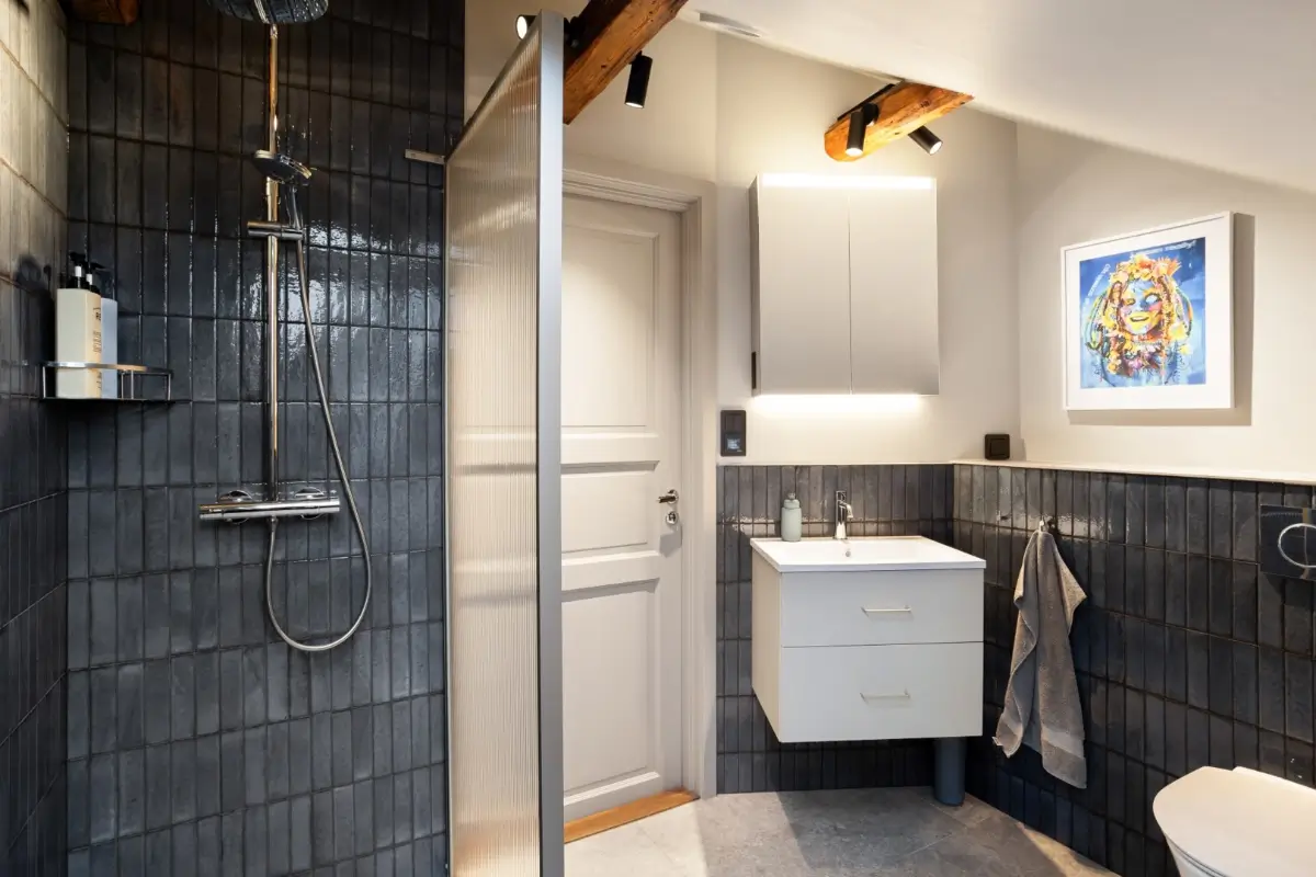 A Harmonious Color Palette in a Luxurious Stockholm Duplex Apartment 27 bathroom blue tiles wooden beams
