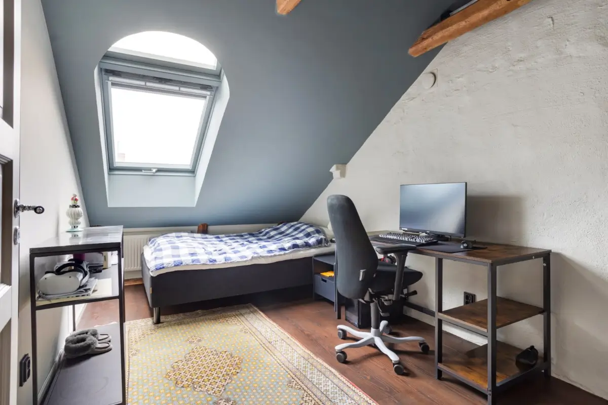 A Harmonious Color Palette in a Luxurious Stockholm Duplex Apartment 25 bedroom blue slanted ceiling wooden beams