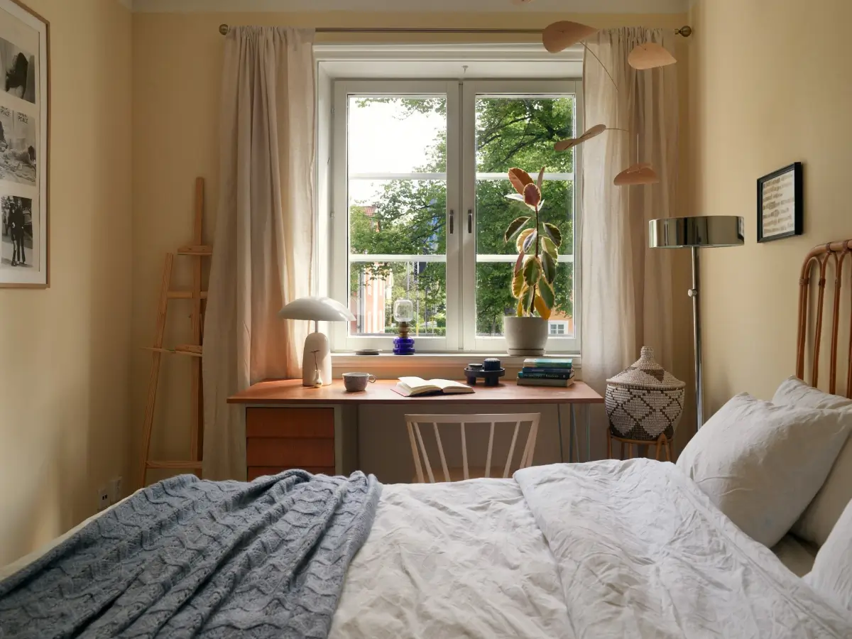 A Muted Color Palette in a Cozy 1920s Apartment in Stockholm 12 bedroom with desk under window nordroom