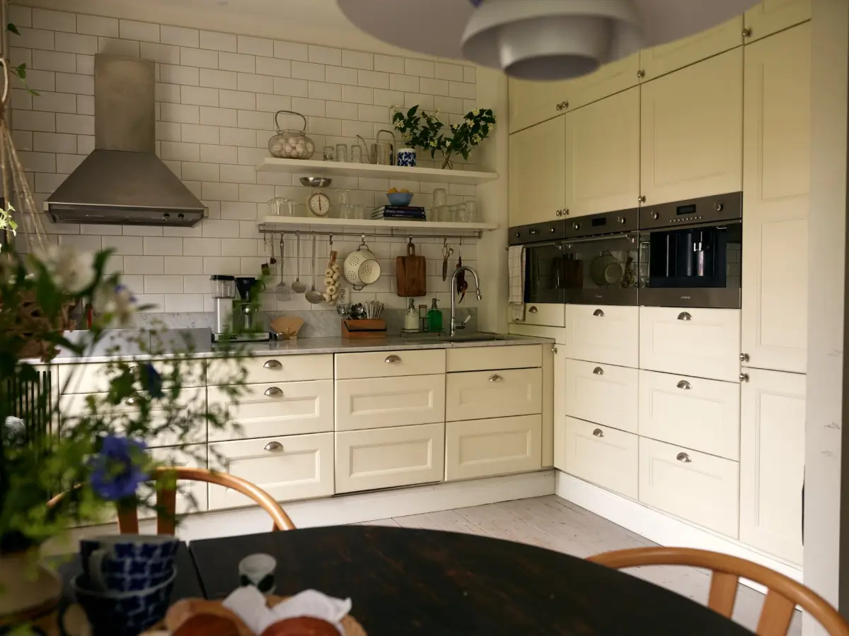 A Muted Color Palette in a Cozy 1920s Apartment in Stockholm 10 classic kitchen white tiles shelves floor-to-ceiling cabinets nordroom