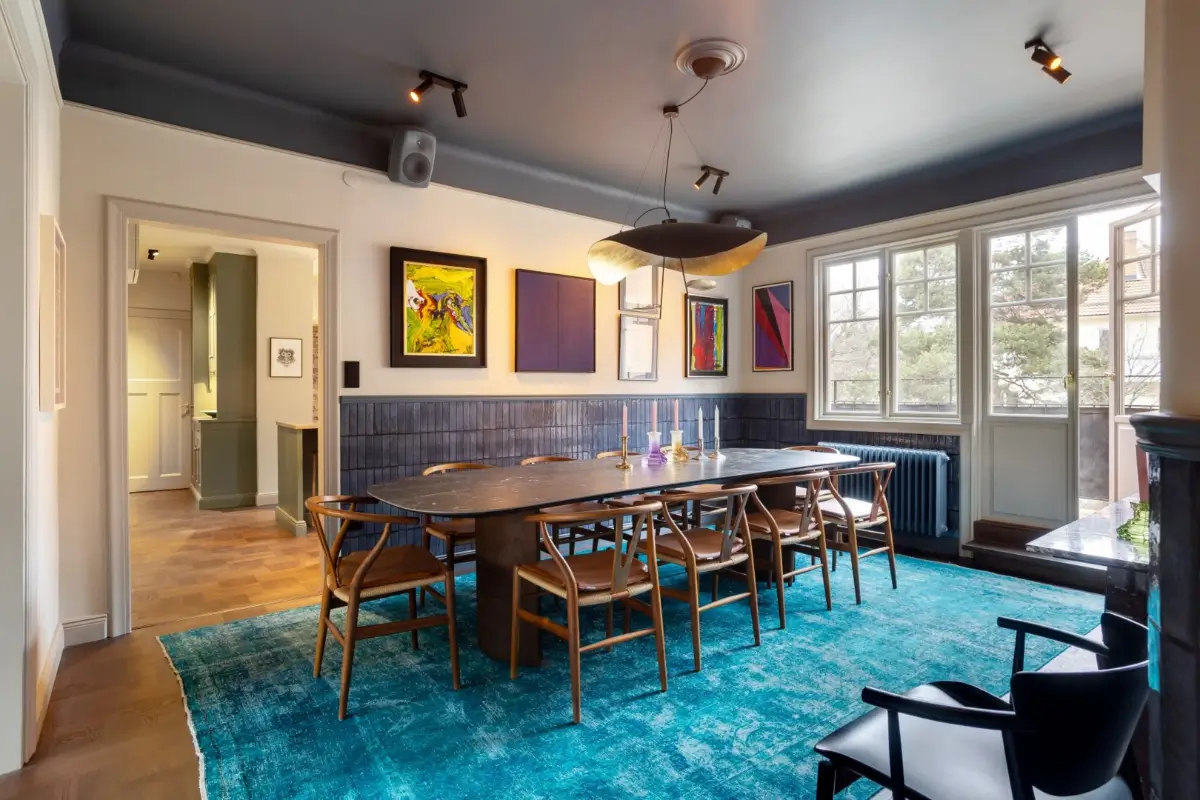 A Harmonious Color Palette in a Luxurious Stockholm Duplex Apartment 3 dining room half blue-tiled walls and blue rug under marble-topped table nordroom