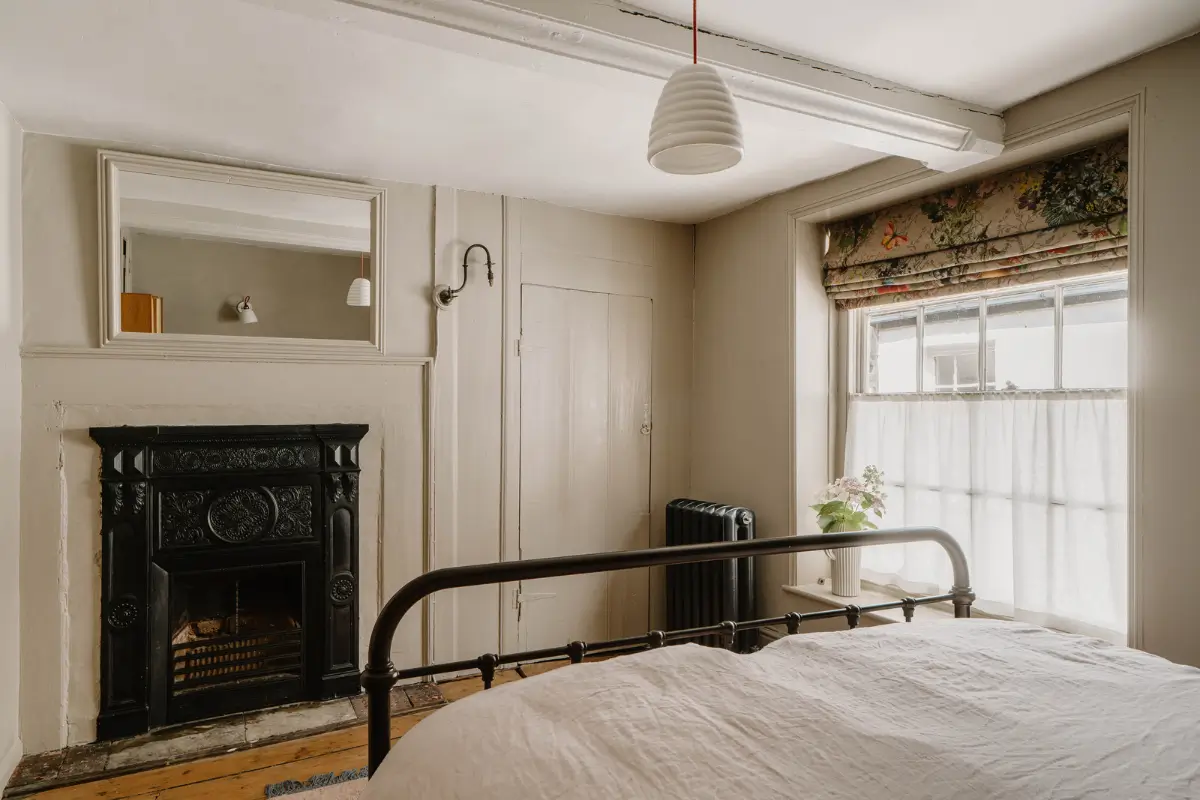 A 17th-Century Home with Original Elements in an English Seaside Town 14 gray bedroom with fireplace and built-in wardrobe