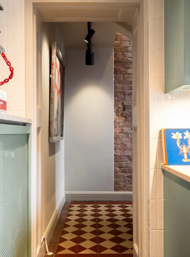 A Harmonious Color Palette in a Luxurious Stockholm Duplex Apartment 20 hall exposed brick checkerboard floor