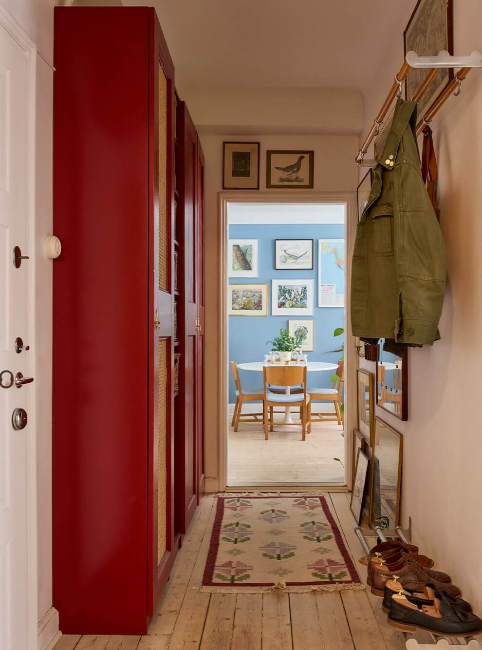 A Blue Living Room Filled with Art in a Swedish Apartment 10 hall with red wardrobes