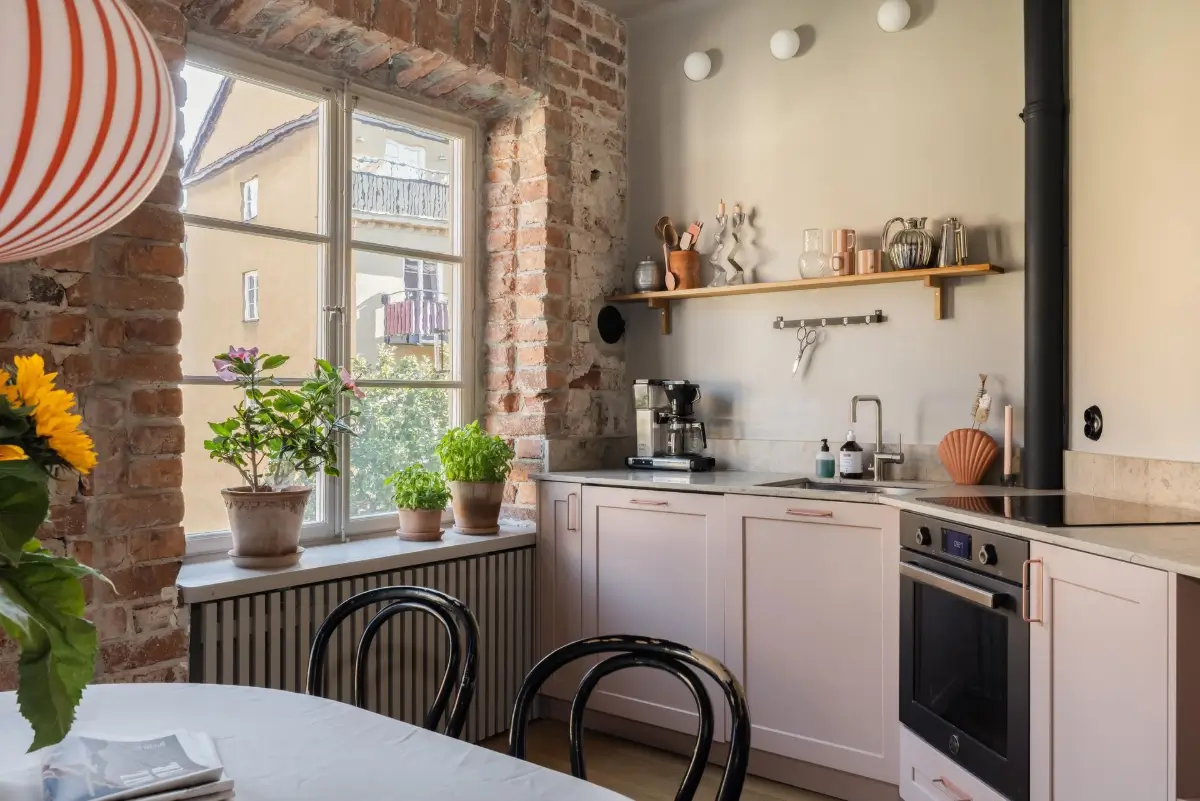 Colorful Rooms in a Practical Stockholm Family Apartment 1 kitchen light pink cabinets exposed brick wall
