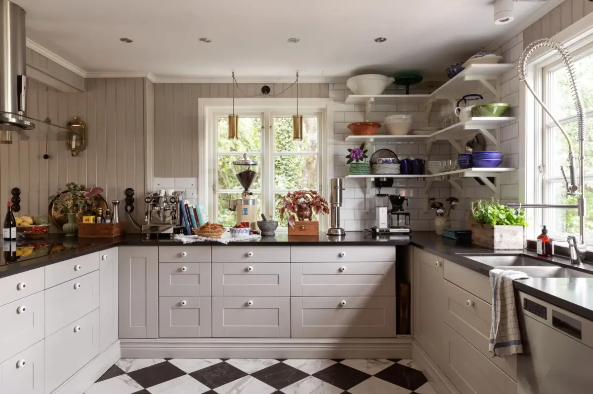 A Renovated 1920s Villa with a Spectacular Garden 6 kitchen tongue and groove paneling shelves checkerboard floor