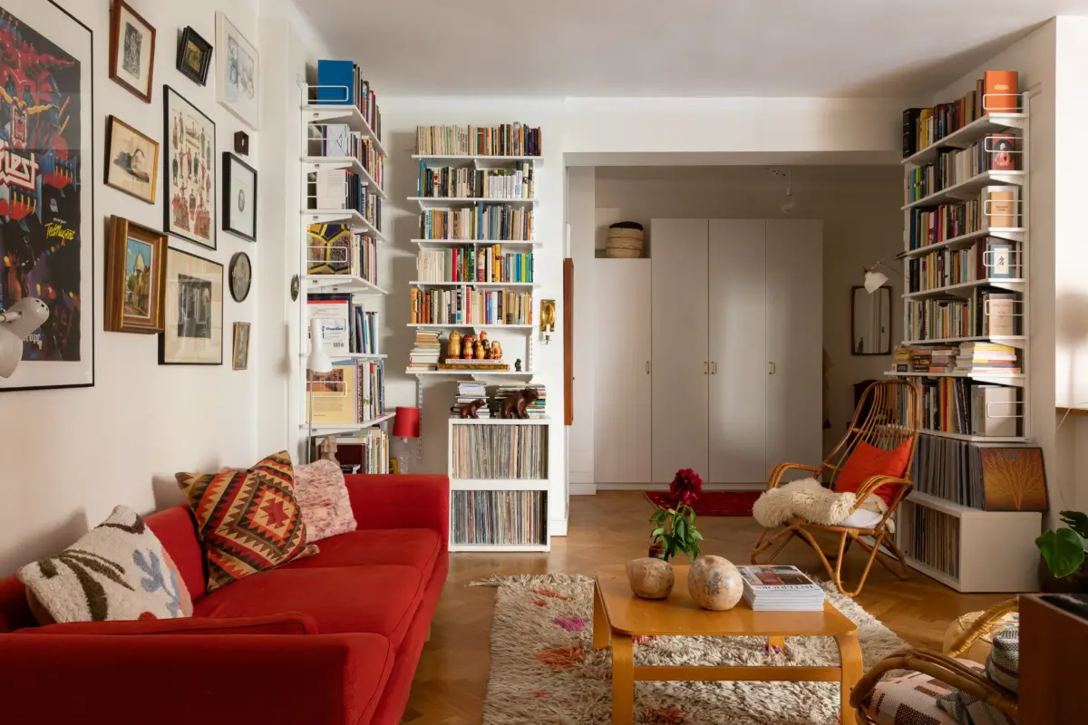 A Cozy 1920s Apartment Filled with Books, Art, and Music 3 living room books and art red sofa