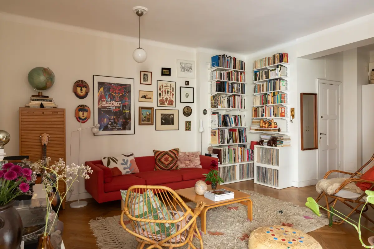 A Cozy 1920s Apartment Filled with Books, Art, and Music 2 living room red sofa art bookshelves