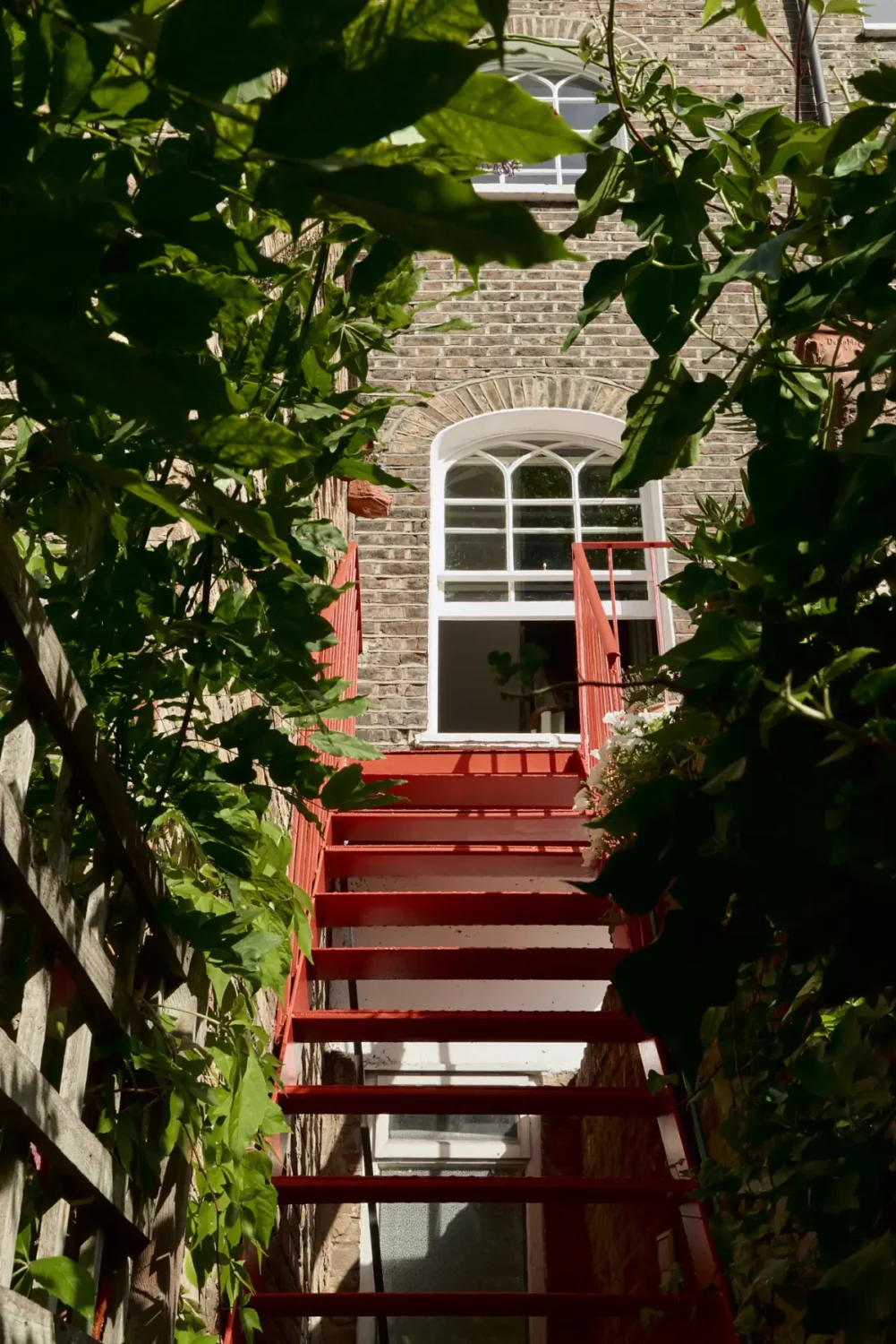 A Classic Victorian Duplex with a Lush, Private Garden in London 32 red steel staircase