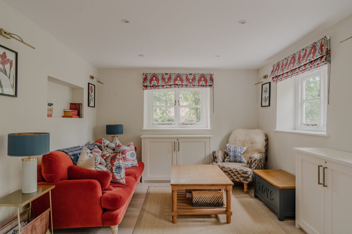 A Stone English Cottage with a Blue and Pink Kitchen 8 sitting room red sofa