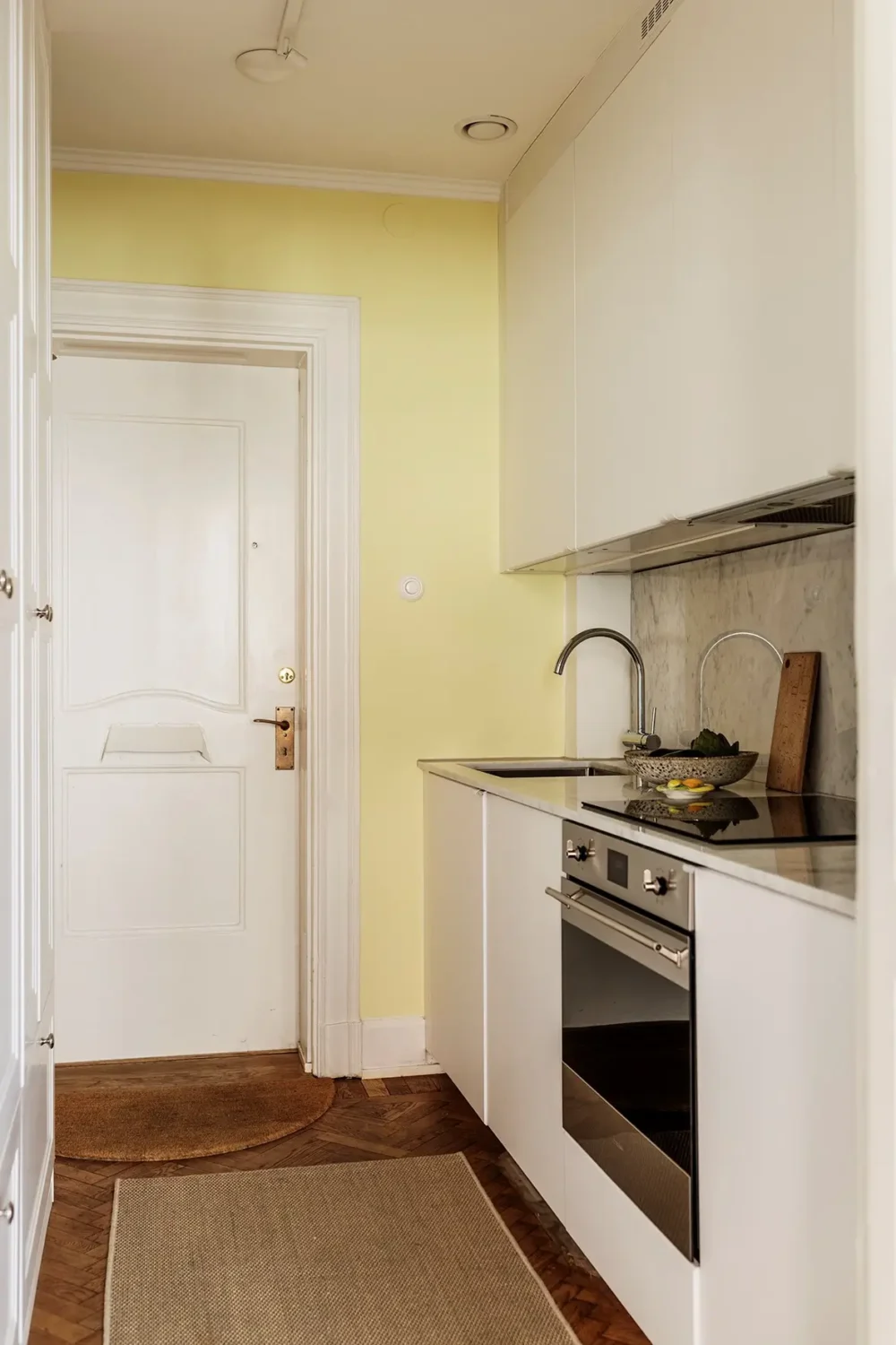 A Farrow & Ball Palette in an Art Nouveau Stockholm Apartment 16 small white kitchen marble backsplash pale yellow wall nordroom