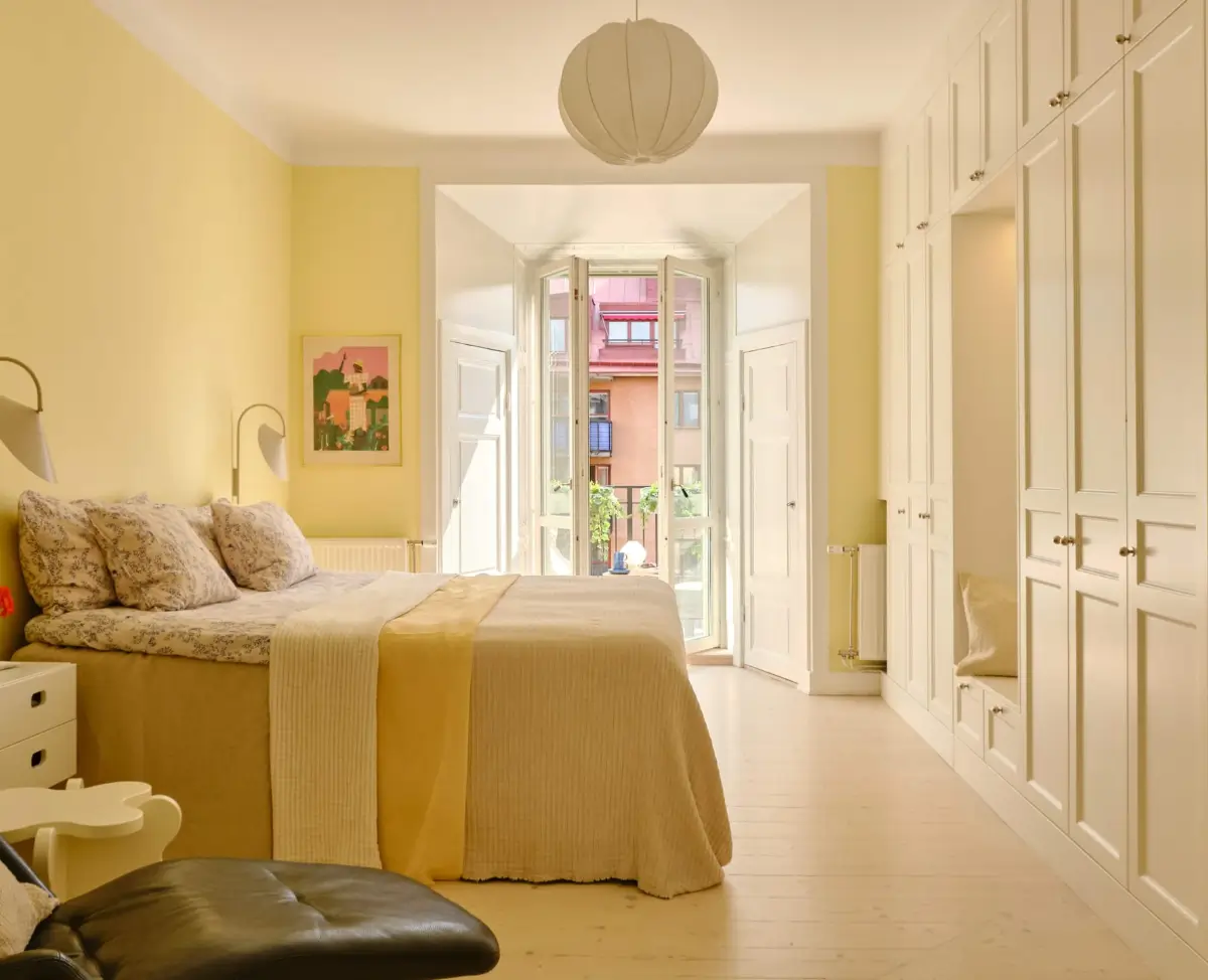 Pastel Hues in a Light-Filled 1880s Apartment in Stockholm 10 spacious butter yellow bedroom with built-in wardrobes nordroom