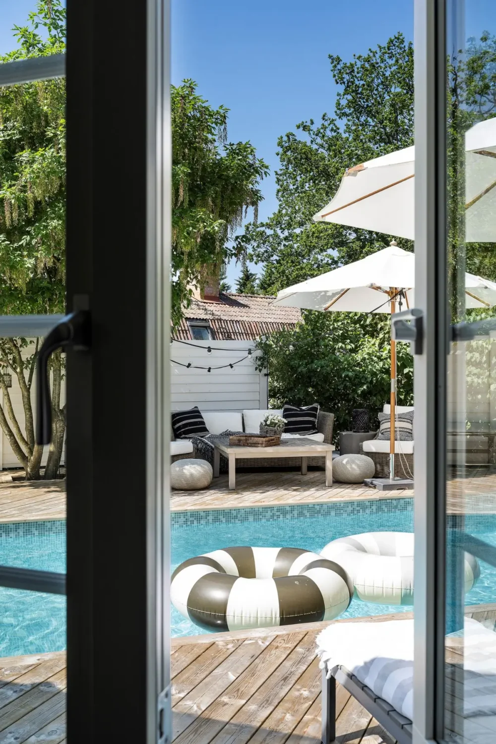 Scandinavian Design Meets The Hamptons in a Swedish Country House 28 view into garden with pool