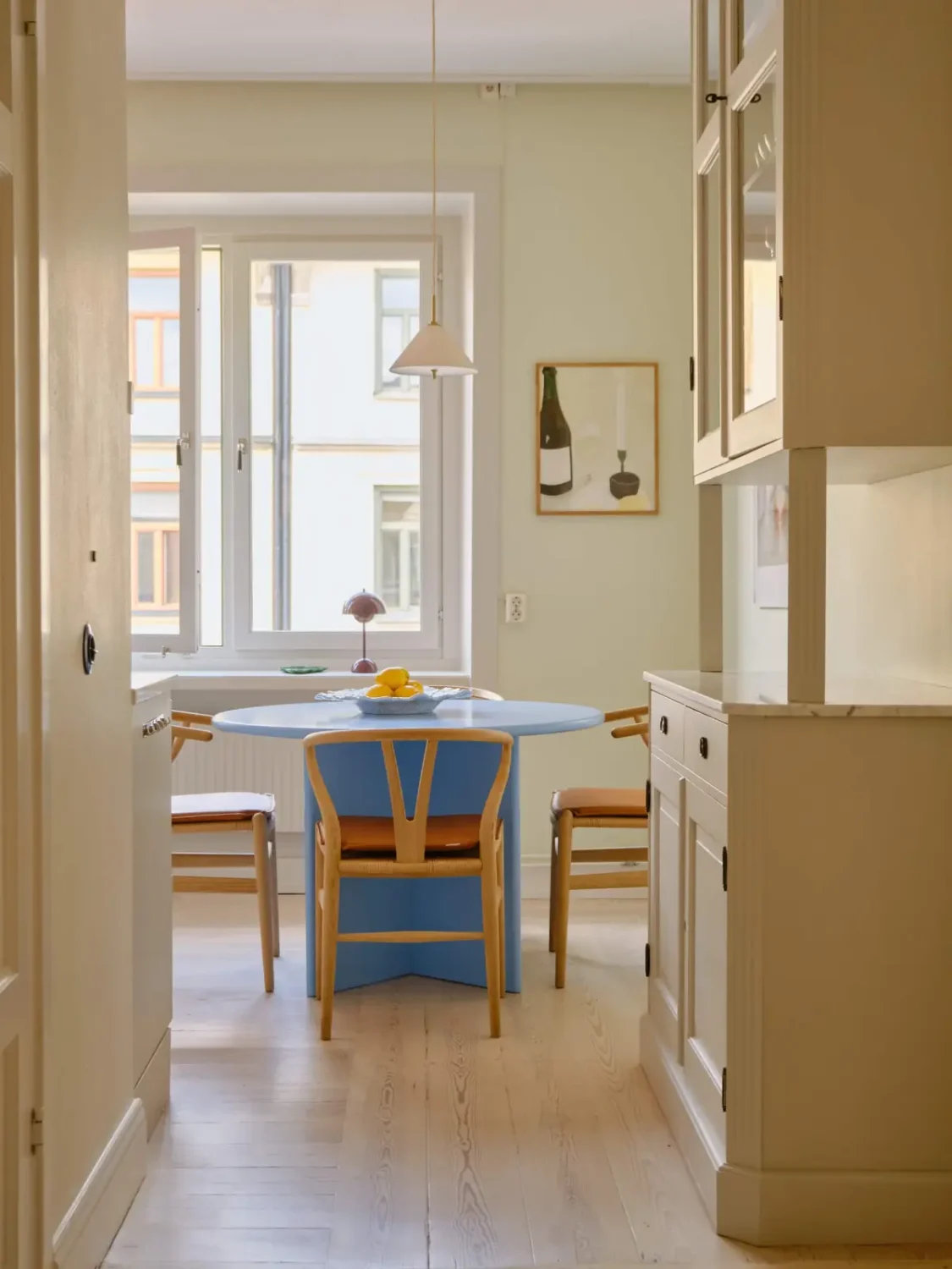Pastel Hues in a Light-Filled 1880s Apartment in Stockholm 18 view-into-kitchen-blue-dining-table-nordroom