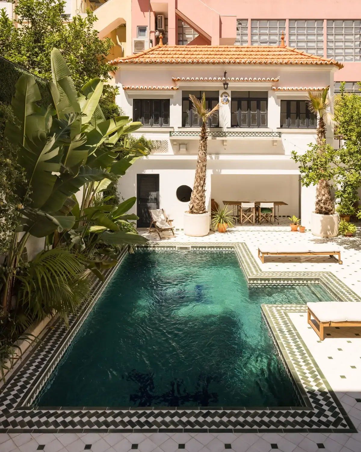 An Art Deco Villa with a Moroccan-Inspired Garden in Portugal 23 walled garden with swimming pool and black and white tiles