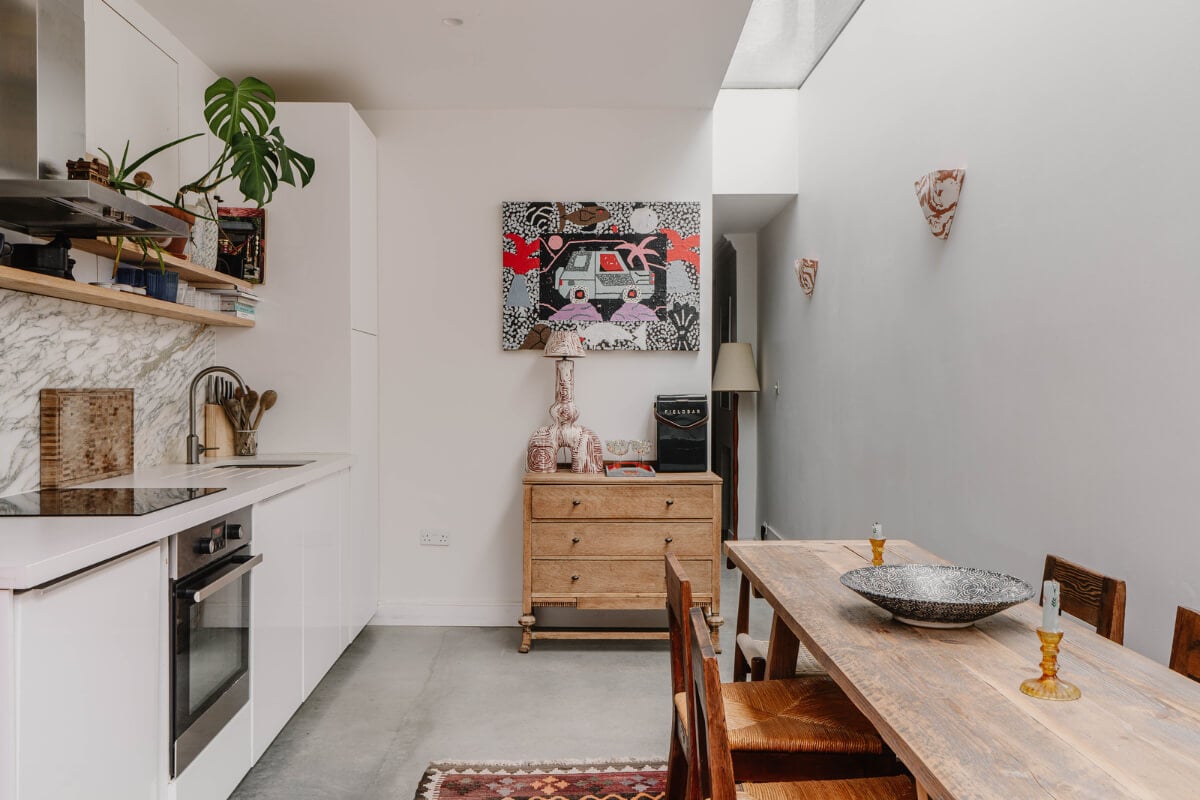 A Modern Ground-Floor Apartment with a Tiny Patio Garden 11 white kitchen wooden table skylight