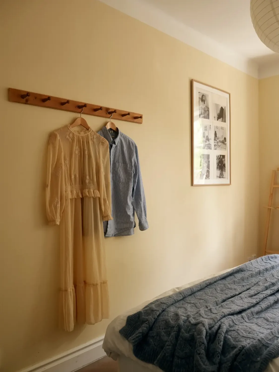 A Muted Color Palette in a Cozy 1920s Apartment in Stockholm 16 wooden hooks yellow-beige bedroom