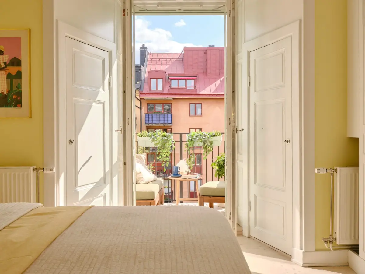 Pastel Hues in a Light-Filled 1880s Apartment in Stockholm 14 yellow-bedroom-built-in-wardrobes-balcony-nordroom