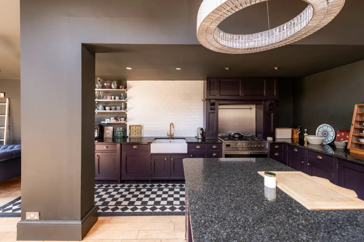 A Dramatic Color Palette in a Large Victorian Family Townhouse 8 aubergine kitchen cabinets black and white floor tiles