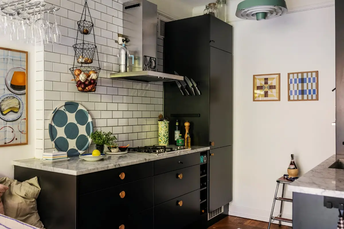 A Charming Swedish Courtyard Apartment Filled with Art 11 black kitchen cabinets white backsplash tiles