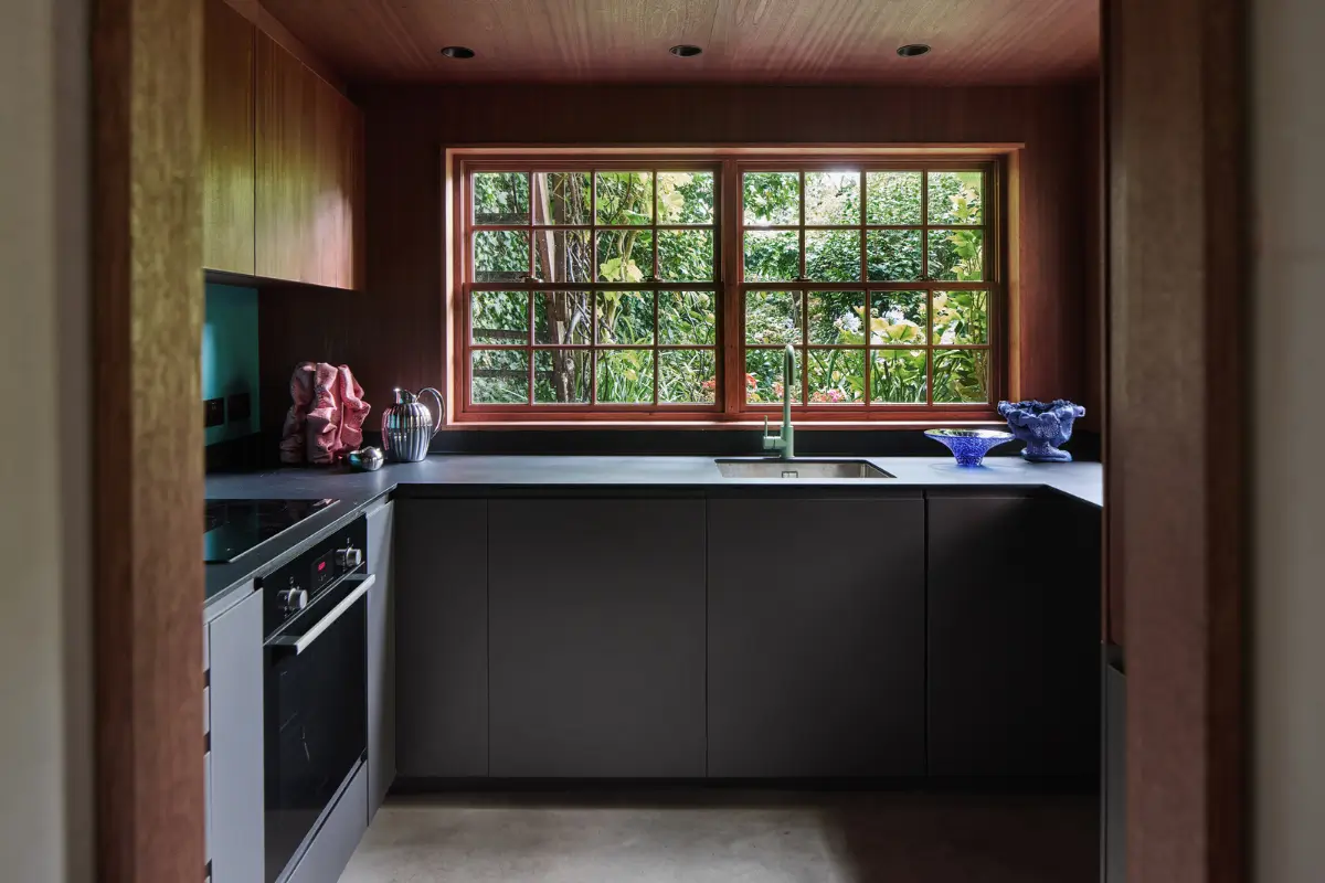 Victorian Grandeur Meets Modern Design in a Camden Square Townhouse 28 dark gray kitchen deep red window frames