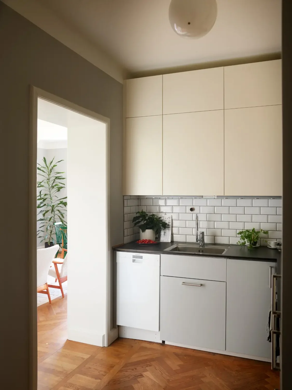 Midcentury Furniture & a Dark Blue Bedroom in a 1930s Apartment 12 gray-white-ktichen white backsplash tiles parquet floor